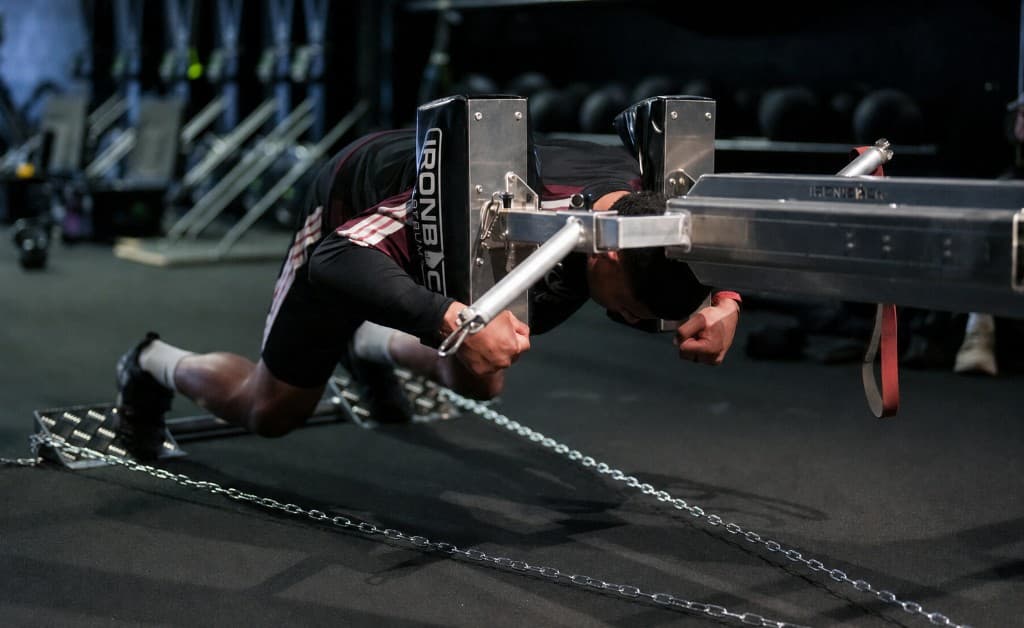 Athlete driving through an Ironback scrum training machine in the gym